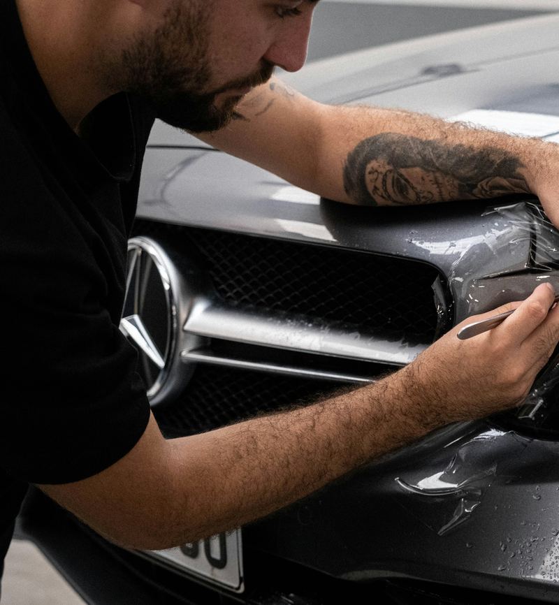 Sorgfältige Arbeit am Scheinwerfer eines Fahrzeugs